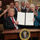 President Donald Trump shows an executive order to loosen restrictions on the Affordable Care Act on Oct. 12, 2017. (Alex Wong/Getty Images)